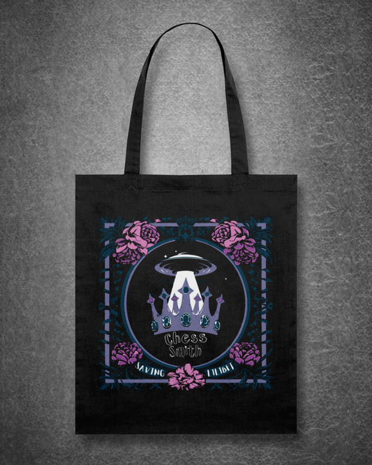 Black tote bag with a graphic design featuring a UFO and floral elements on a gray background